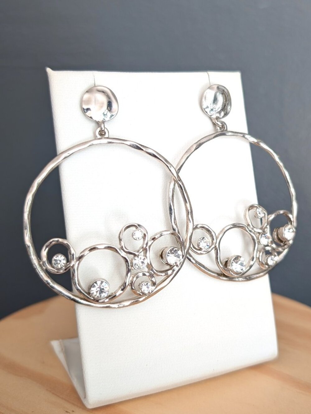 Silver tone hammered open hoop earrings with faux diamond accents
